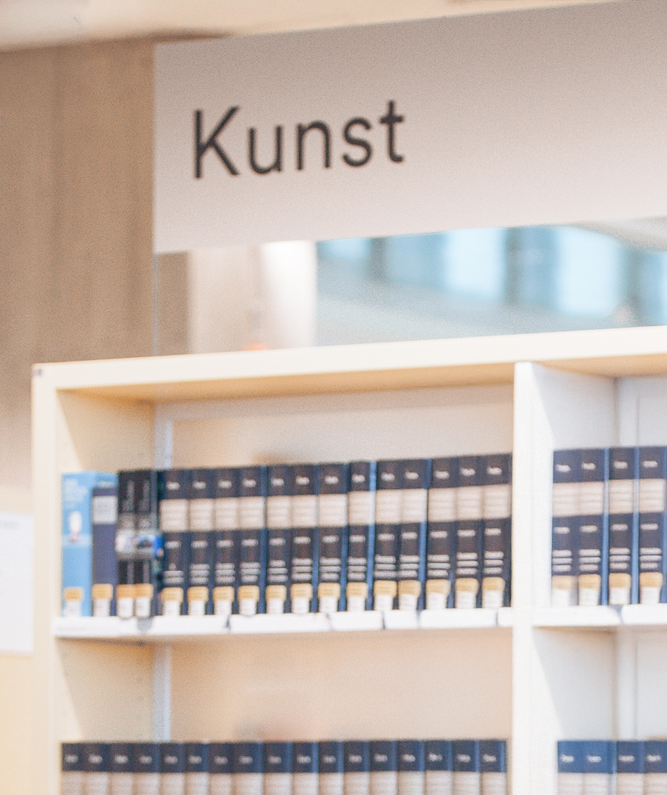 Schild mit dem Titel Kunst über einem Bücherregal mit kunsthistorischer Literatur in einer Bibliothek
